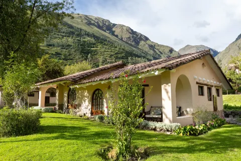 Vista de fachada de hotel de Valle Sagrado en Urubamba con jardin y cerros | Hotel Inti Punku